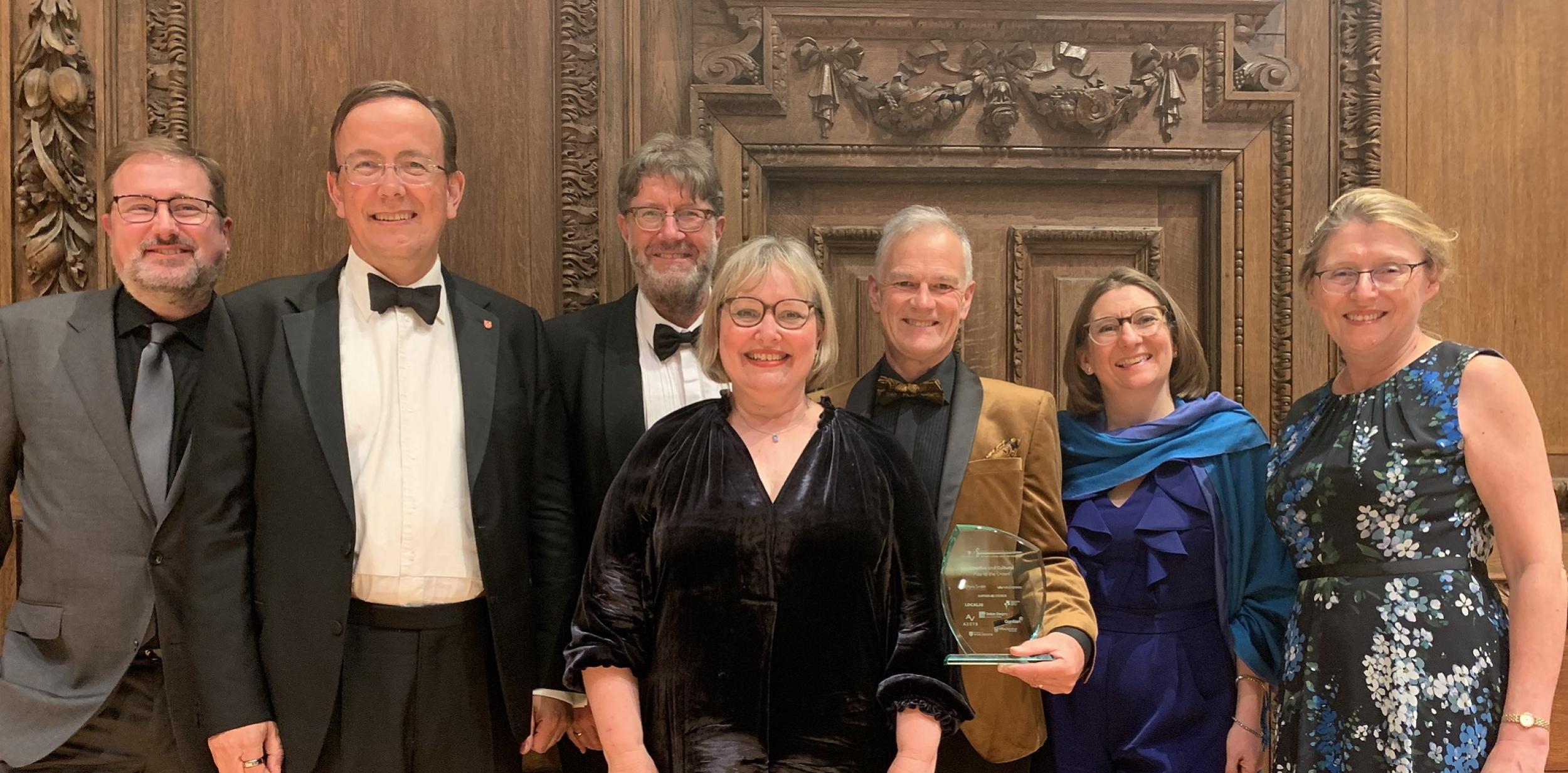 Members of Play to the Crowd and Winchester city council holding a glass award