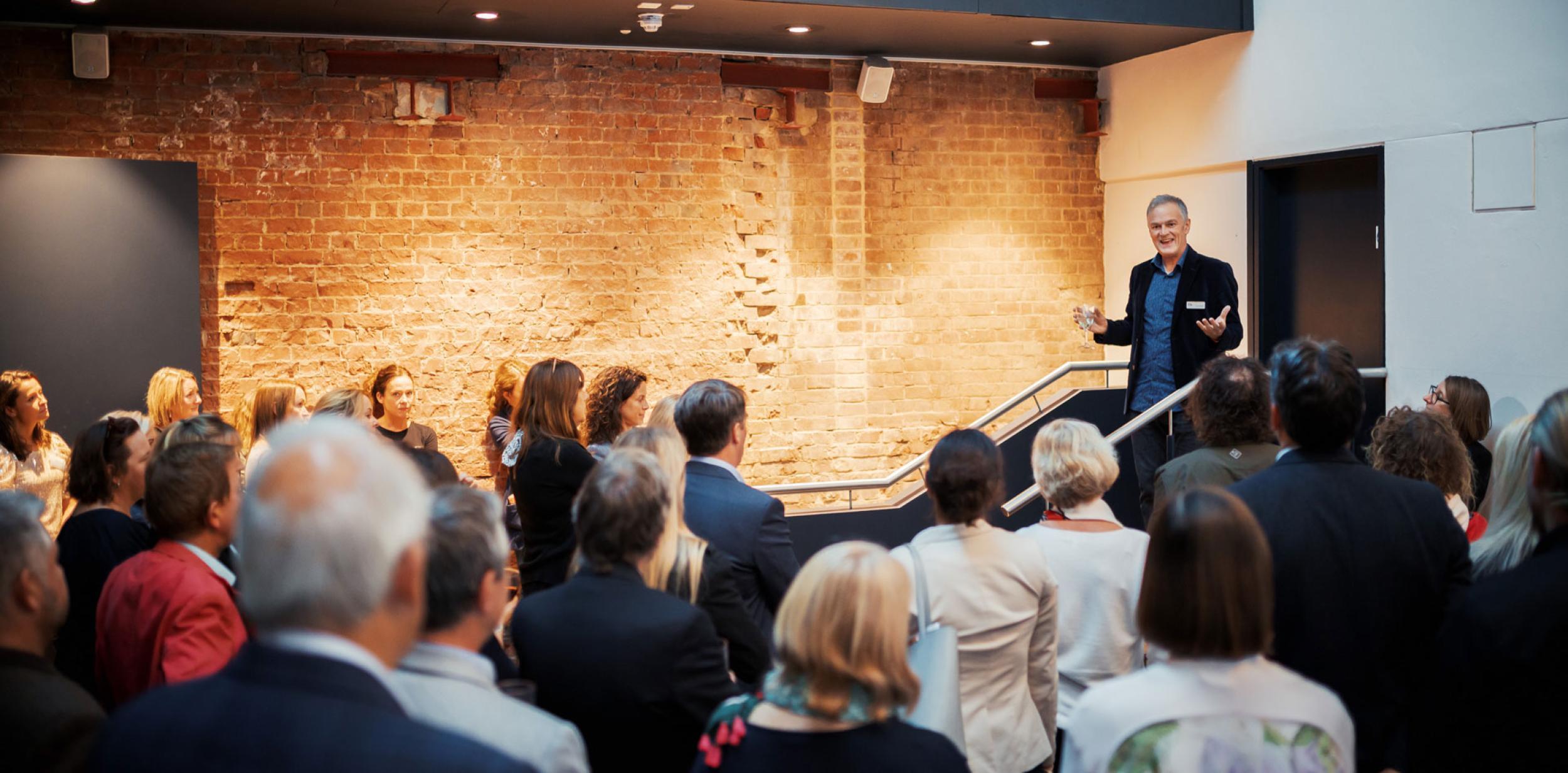 Deryck Newland giving a speech to a crowd of people