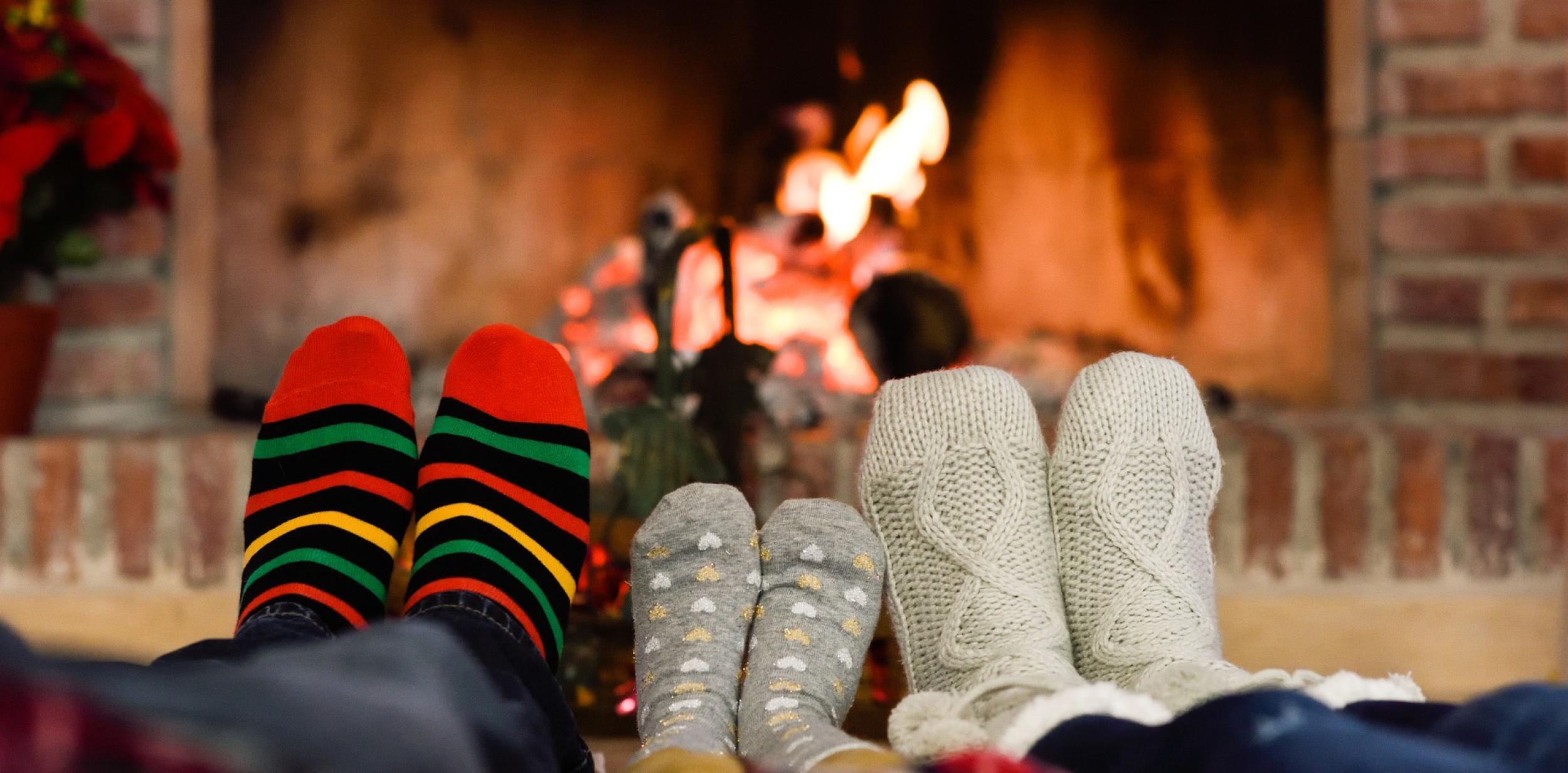 Feet wearing warm socks in front of a cosy fire