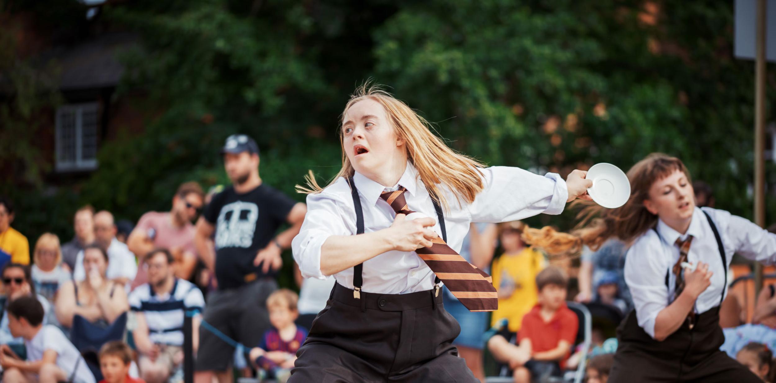 A young lady dancing in a suit