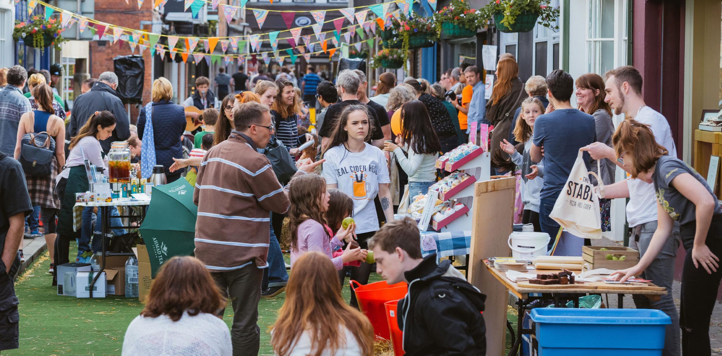 Market stalls in the street with a busy group of people