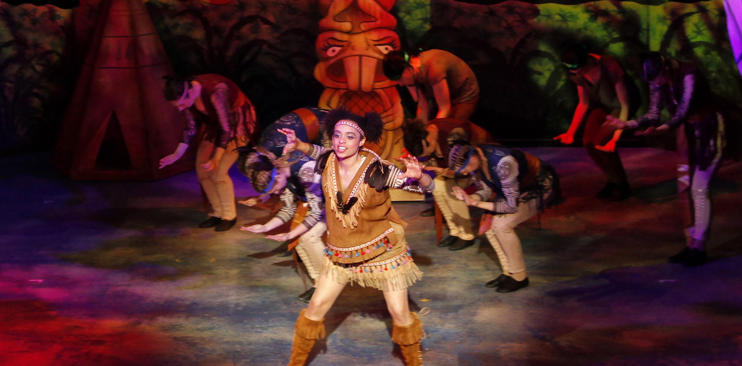 Panto character dancing on stage in native american costume