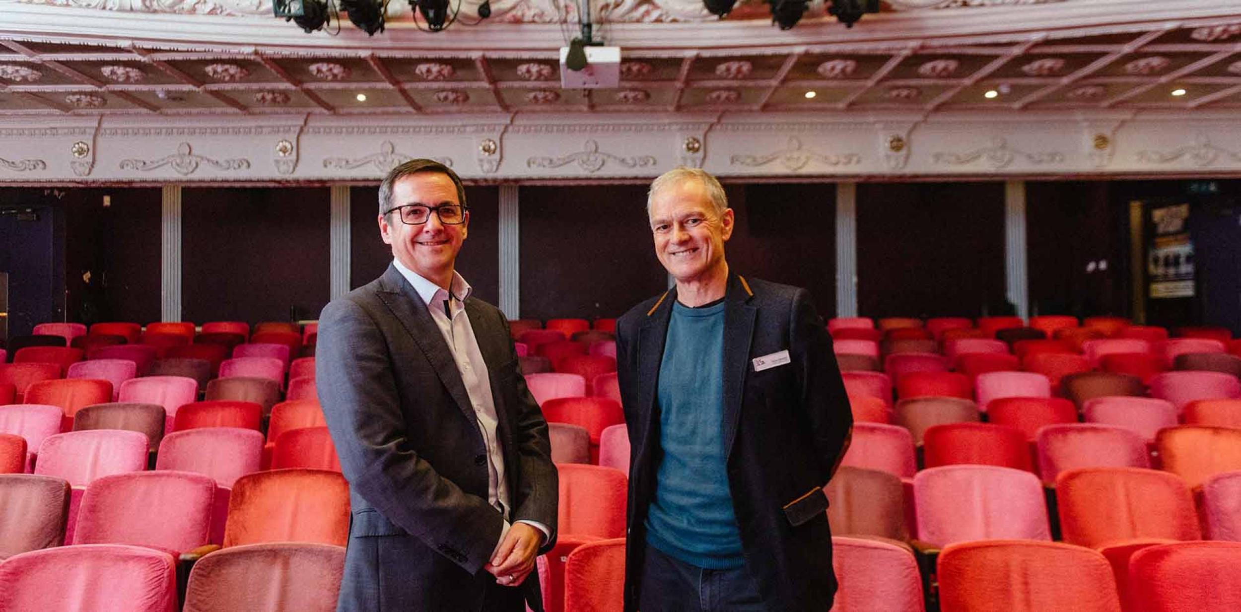 Two men standing in theatre auditorium