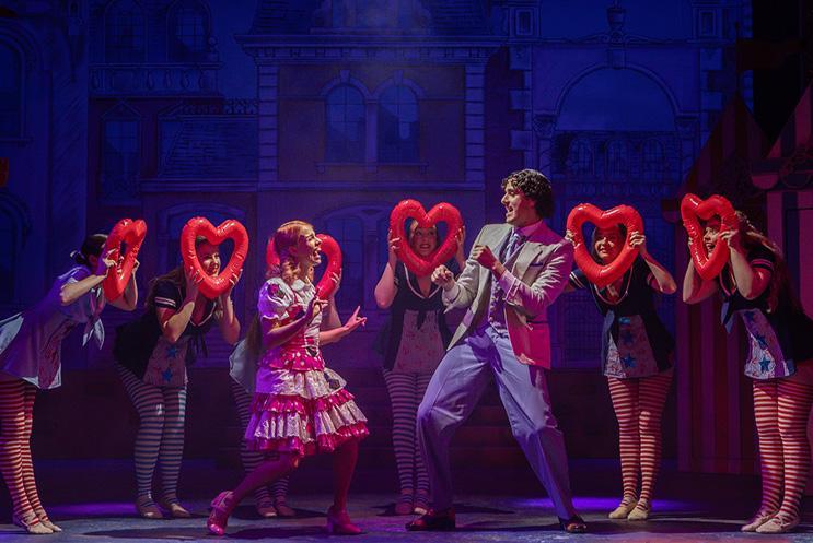 Cinderella and Prince Charming surrounded by young performers with hearts