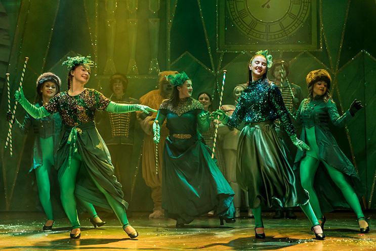 Wizard of Oz young performers dressed in glittery green and dancing