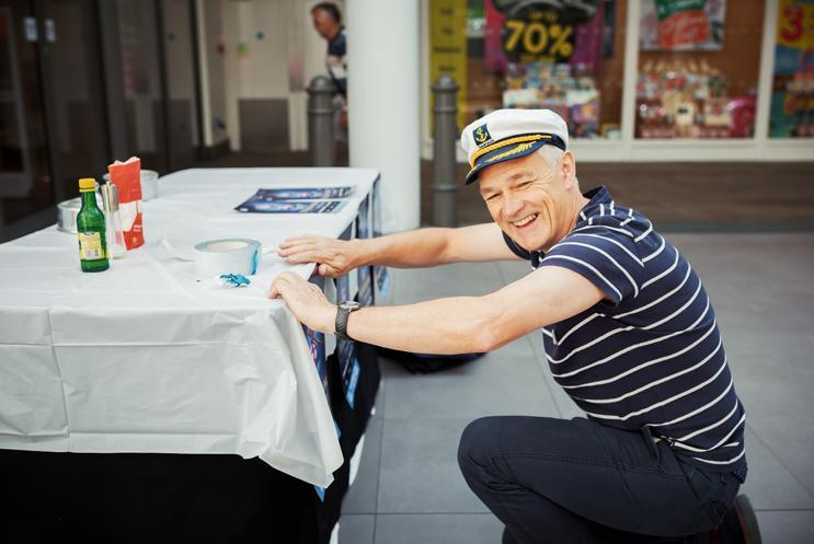 Deryck crouching behind a table