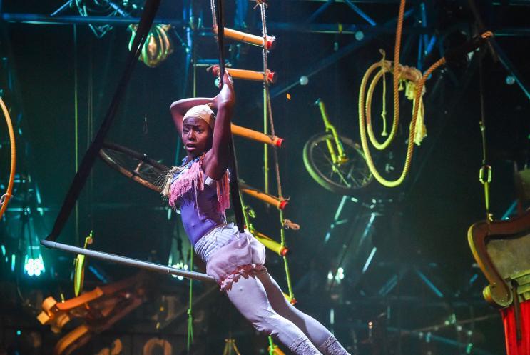 A female acrobat flying above the stage