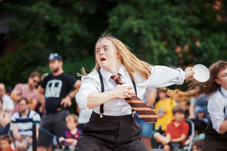 A young lady dancing in a suit