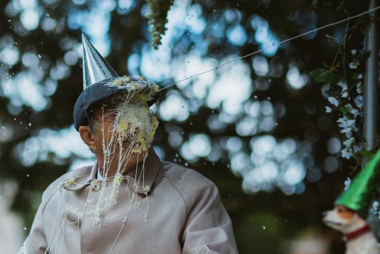 Man wearing party hat with face covered in silly string