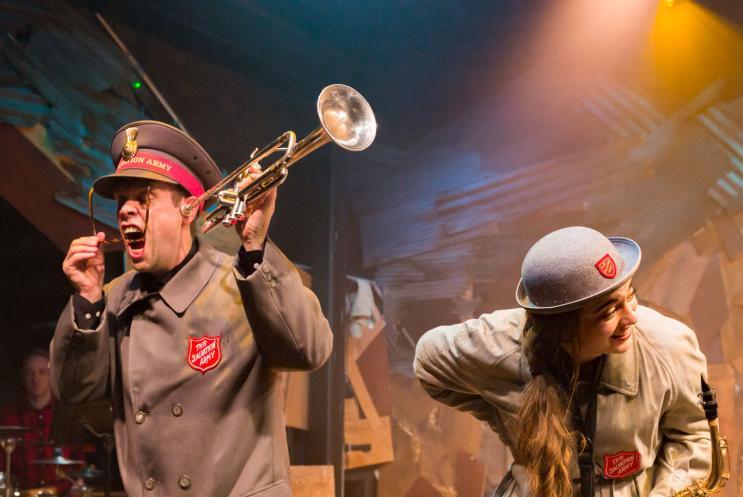 A man and a woman in military uniform.  The man is holding a trumpet.