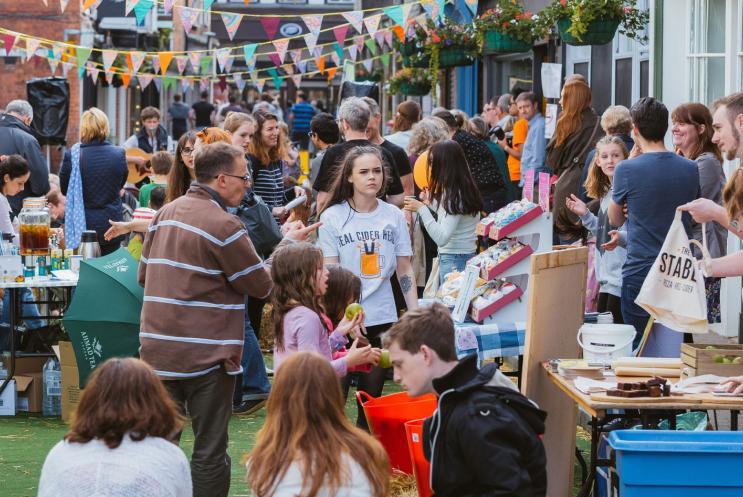 Market stalls in the street with a busy group of people