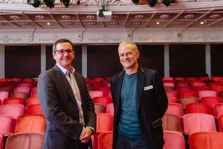 Two men standing in theatre auditorium