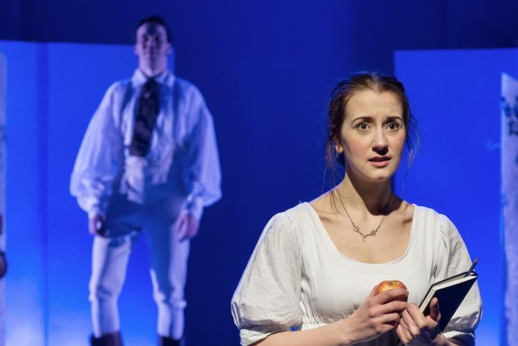 A young woman in white holding a book